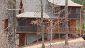 A two-story log cabin with a balcony, surrounded by trees. - Beautiful Custom Cabin on almost 2 acres with lots of privacy (Blue Ridge)