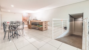 A modern kitchen with a dining area, a built-in bench, and a white door leading to a balcony. - Hotel Imperial Palace (Bom Jesus Da Lapa)