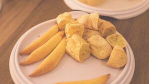 A plate of breadsticks on a wooden table. - Hotel Imperial Palace (Bom Jesus Da Lapa)