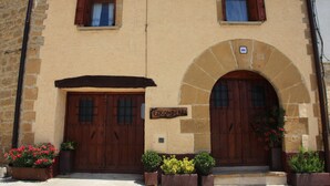 A building with two wooden doors, a sign reading "EZKONBERG", and a stone archway. - EZKONBERRI VACATION RENTAL (Unzué)