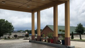 Une station-service dotée d’un auvent, de plusieurs piliers et de plantes en pot.