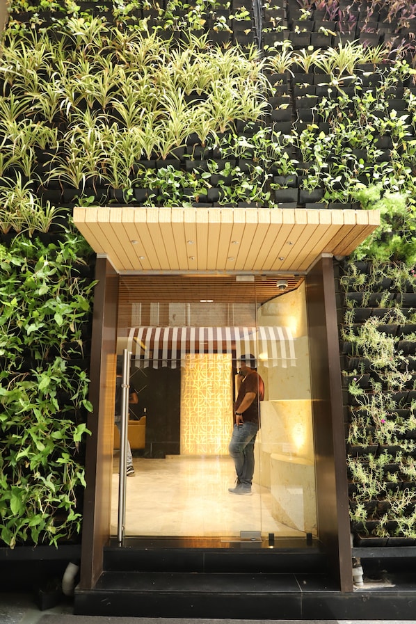 Enter a serene oasis with lush greenery surrounding the entrance.