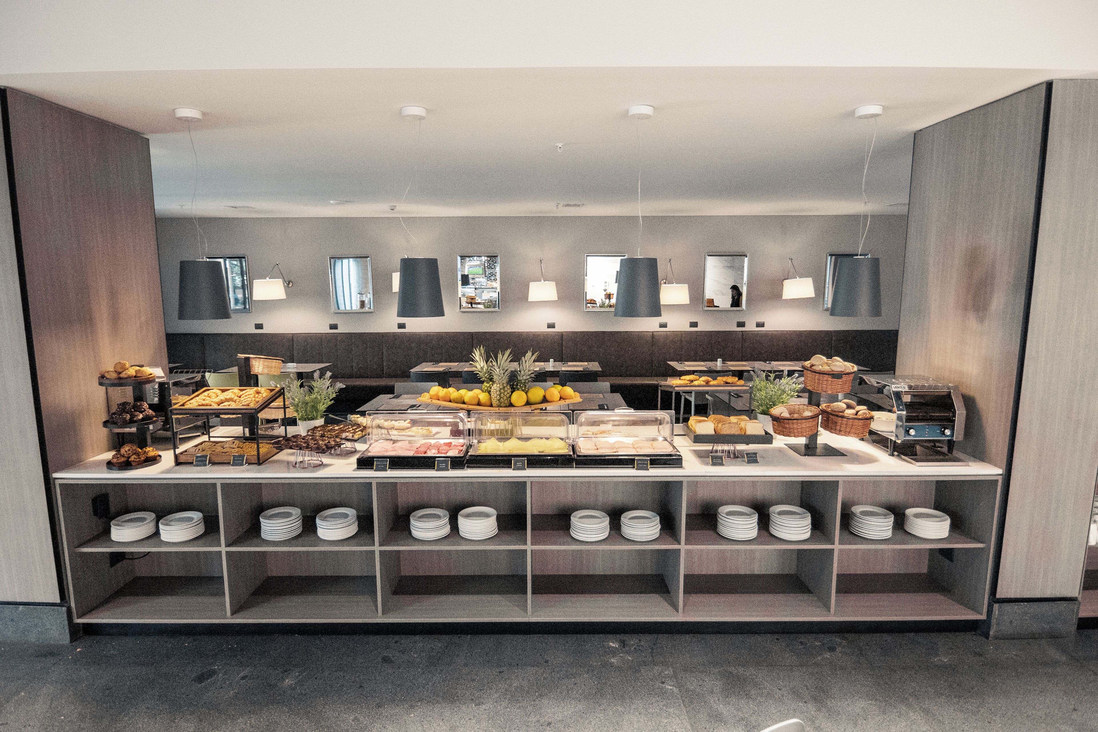 A buffet setup with various food items and a self-service station.