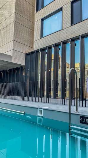Una piscina al aire libre, sillones reclinables de piscina