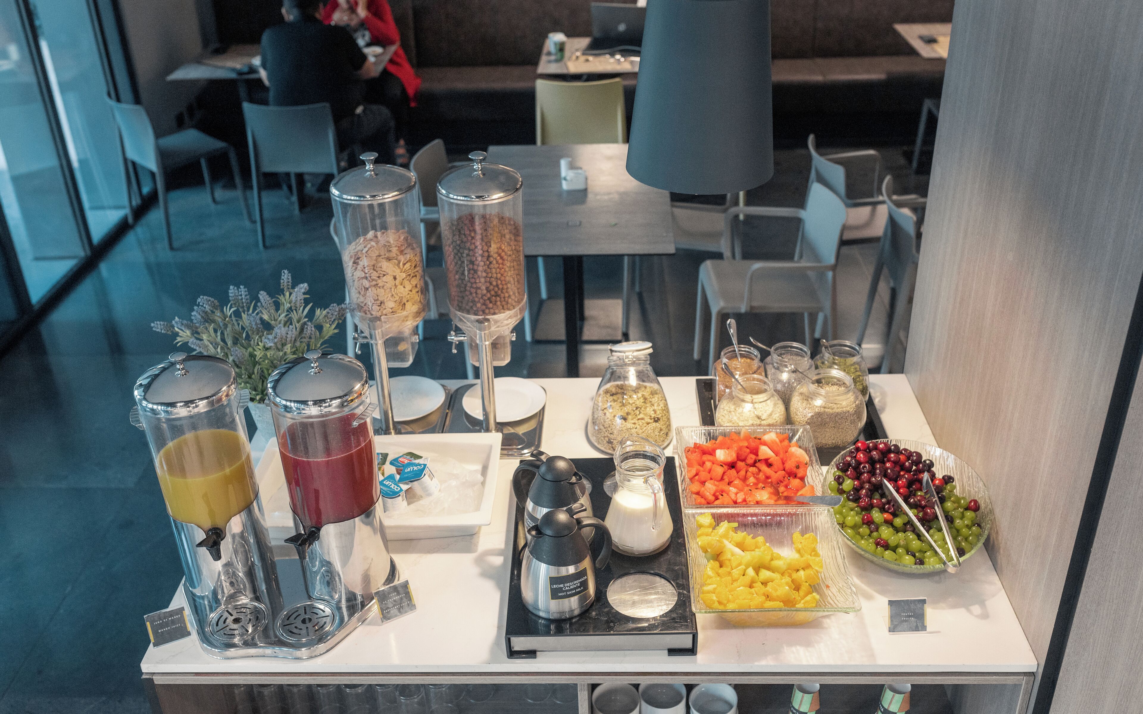 A buffet setup with various food and drink options, including fruits, grains, and beverages.
