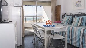Una stanza accogliente con un letto, una scrivania e una sedia. Una finestra offre vista sul mare.