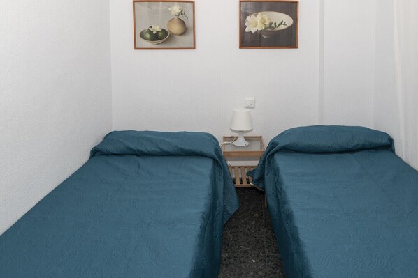 A room with two single beds, a bedside table with a lamp, and two framed pictures on the wall. - PRADO, B-6º-64 PK INT 102 (Cullera)
