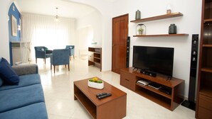Een moderne woonkamer met een bank, salontafel, televisie en entertainmentsysteem.