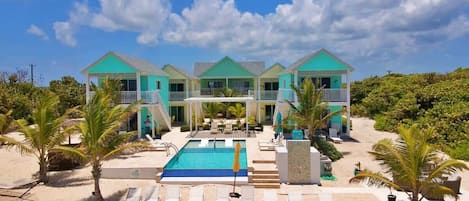 Resort com piscina, vários edifícios e ambiente de praia.