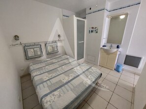 2 dormitorios y tabla de planchar con plancha