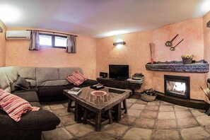 Télévision, cheminée, lecteur de DVD, livres