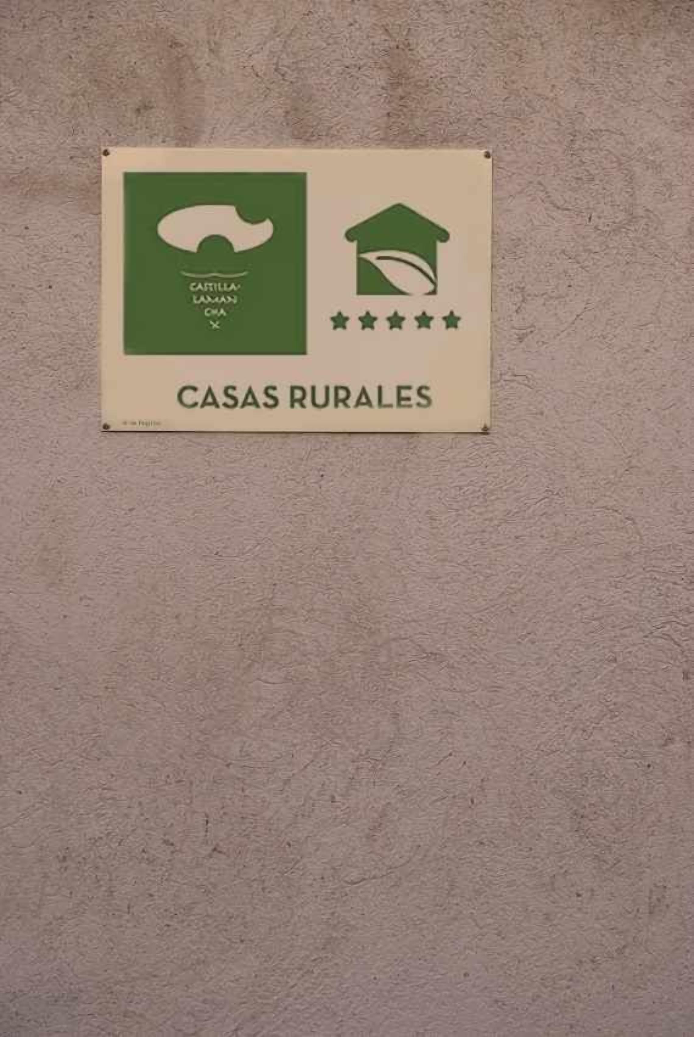 Une enseigne avec le texte « CASAS RURALES » et une illustration représentant une maison avec un toit et des étoiles.