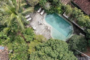 Una piscina al aire libre, sillones reclinables de piscina