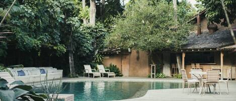 Una piscina al aire libre, sillones reclinables de piscina