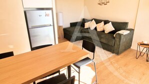 A compact living space with a kitchenette, a sofa, and a dining area.