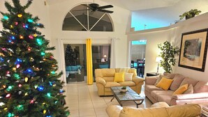 Un salón amplio con un gran árbol de Navidad, dos sofás y una mesa de centro.