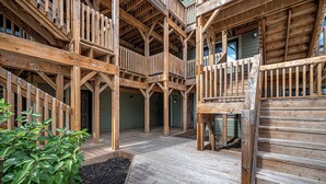 Een houten gebouw met meerdere verdiepingen, balkons en een open centrale ruimte.