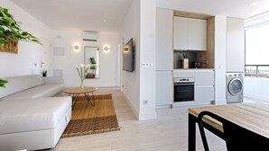 Un appartement moderne comprenant un salon, une cuisine et un coin repas.