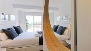 Une chambre d’hôtel moderne avec un grand lit, deux tables de chevet et un balcon avec vue.
