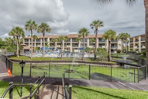 Guests can enjoy a refreshing swim in the pool surrounded by lush greenery and palm trees.