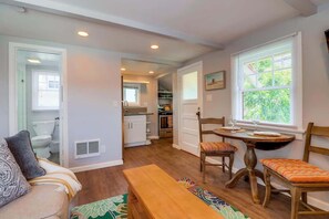 A compact living space with a dining area, a kitchen, and a bathroom.