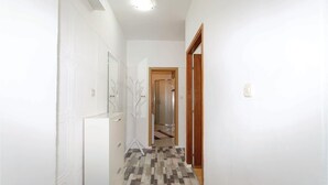 A hallway with a patterned floor, a mirror, and a door leading to a shower area. - Amazing apartment in Zadar with WiFi (Zadar)