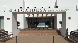 Der Eingang zum Alcaidesa Links Golf Resort mit freier Sicht auf die Eingangstreppe und einer Bank auf der linken Seite.
