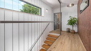 Eine moderne Treppe mit Holzdielen und Metallgeländern, die zu einer oberen Etage führt.