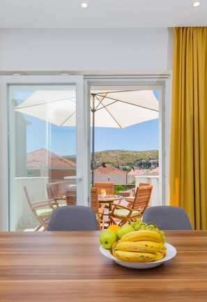 Enjoy meals in this stylish dining area with a table for two, featuring a fresh fruit platter.