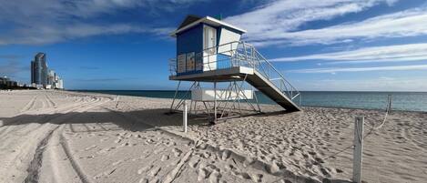 Ranta lähistöllä, aurinkotuoleja, rantapyyhkeitä