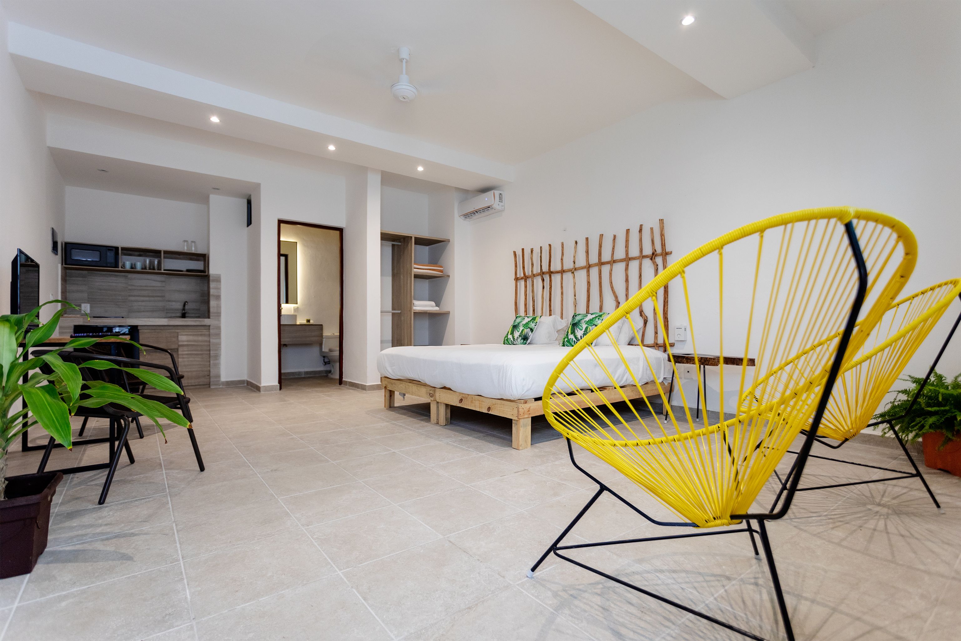 Una habitación amplia con una cama, zona de comedor y cocina.