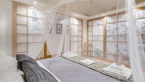 A bedroom with a bed, a chair, a bedside table, and a window with a view. - VENETO COMFORTABLE APARTMENT (one night for up to 6 people) (Roma)