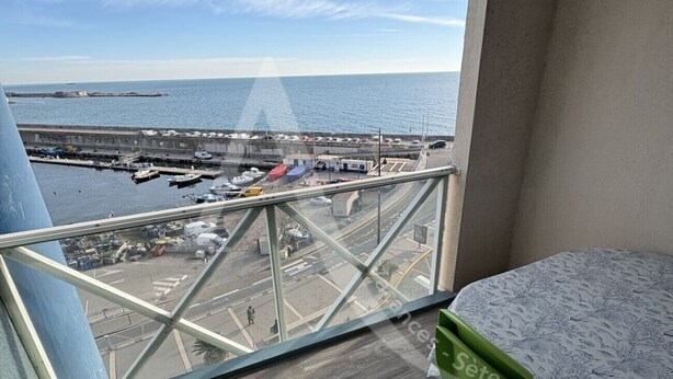 A balcony with a view of the sea and a marina.