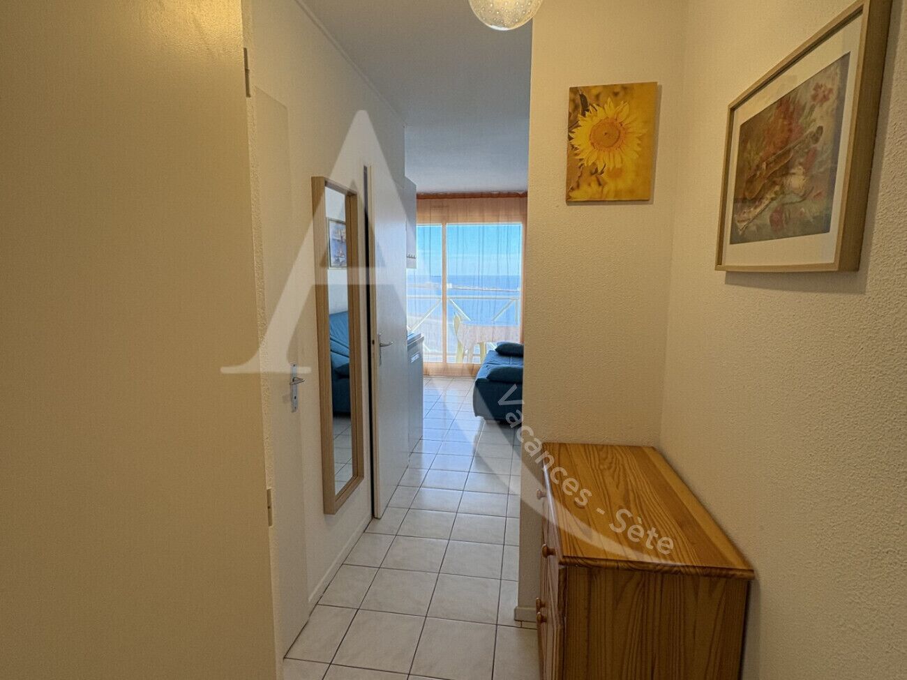 A hallway with a wooden cabinet, a door, and a framed picture on the wall.