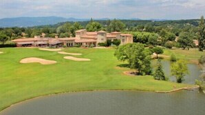 Un parcours de golf doté d’un club-house et d’un étang.