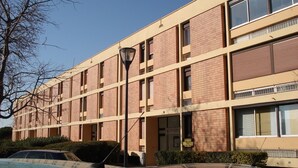 A multi-story building with a brick facade, large windows, and a flat roof. - 45m² Apartment in Balaruc-les-Bains, pets allowed (Balaruc-les-Bains)