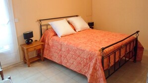 A bedroom with a bed, bedside tables, and a hanging light fixture. - 45m² Apartment in Balaruc-les-Bains, pets allowed (Balaruc-les-Bains)