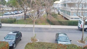 A parking lot with several cars, a building with a modern design, and a tree in the foreground. - 45m² Apartment in Balaruc-les-Bains, pets allowed (Balaruc-les-Bains)