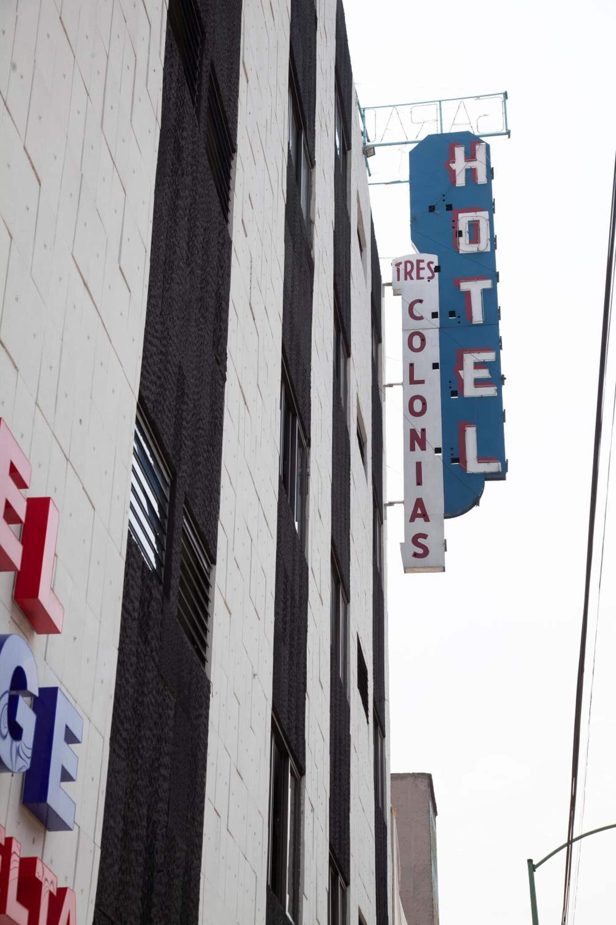 A hotel sign with "HOTEL COLONIAS" and a smaller sign below it reading "TRES COLONIAS".