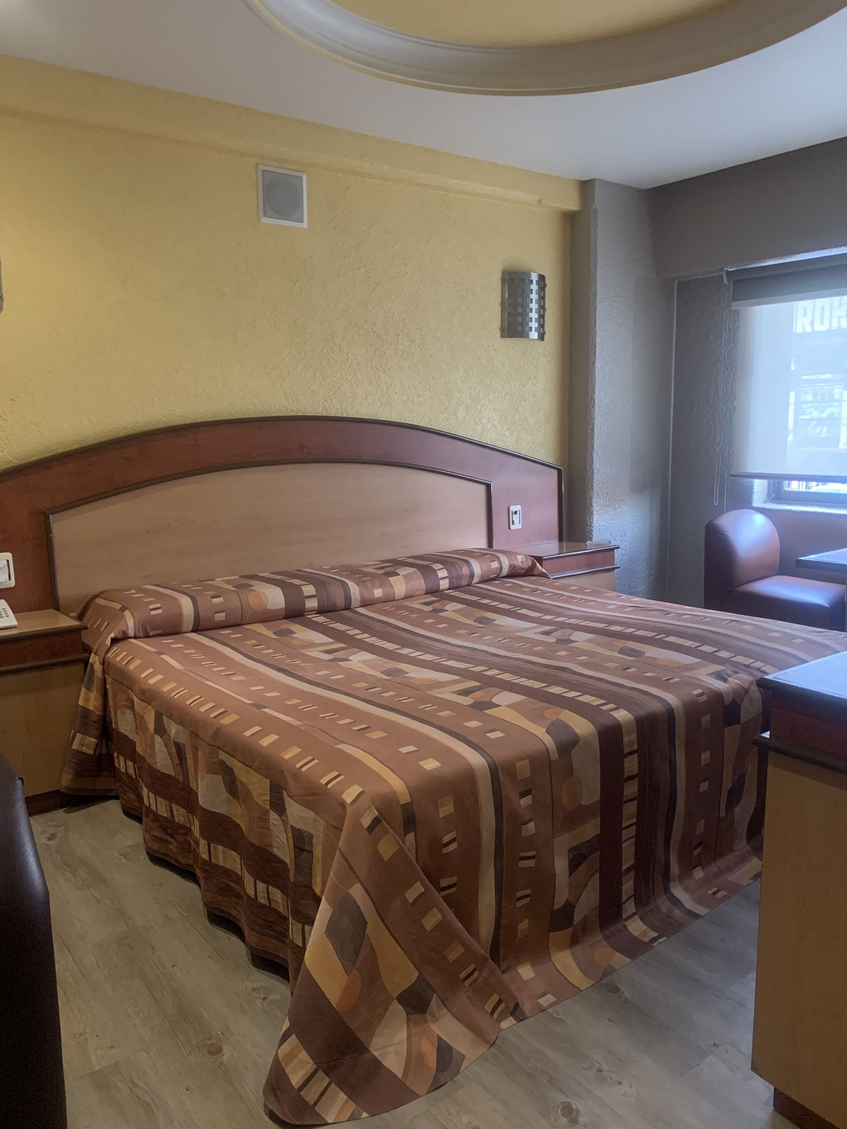 Una habitación de hotel con una cama grande, un escritorio y una silla.