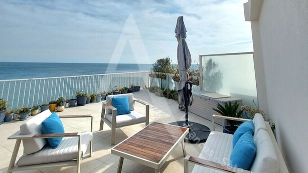 A terrace with outdoor furniture, a view of the sea, and potted plants. - APPARTEMENT 3 CHAMBRES, GARAGE, LARGE TERRASSE VUE UNIQUE (Sète)