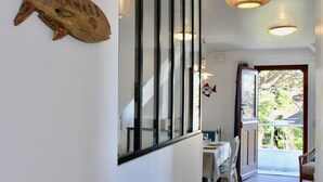 A hallway with a dining area, a fish decoration on the wall, and a view of the outdoors. - "Secrets of Petit Rohu" - 2ch, garden & beach (Saint-Pierre-Quiberon)
