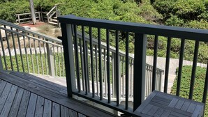 A wooden deck with a railing overlooking a beach and ocean. - OCEANFRONT Villa in Mariners Watch! (Kiawah Island)