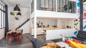 Un appartement moderne de style « loft » comprenant un coin repas, une cuisine et un espace de vie.