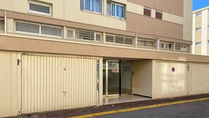 En byggnad med en beige fasad, stora metalldörrar och ett platt tak.