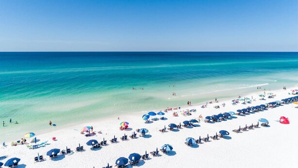A beach with white sand, clear turquoise water, and numerous umbrellas. - Luxury Bayside Sandestin, Beach, 2 Golf Carts (Miramar Beach)