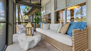A wicker sofa with cushions, a white table, and a lantern. - Luxury Bayside Sandestin, Beach, 2 Golf Carts (Miramar Beach)