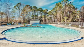 A clear swimming pool surrounded by trees, with lounge chairs and a lifebuoy along the edge. - Luxury Bayside Sandestin, Beach, 2 Golf Carts (Miramar Beach)