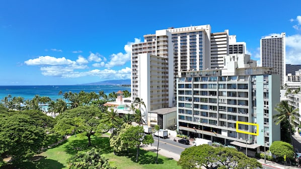 A multi-story hotel with a pool area and a view of the ocean.