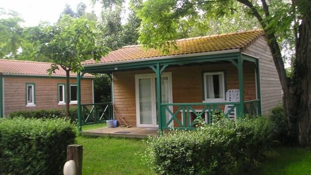 A small, single-story wooden house with a green porch and a tiled roof. - EMPL 3 Mobile home 4 A 6 people (Notre dame de Riez)
